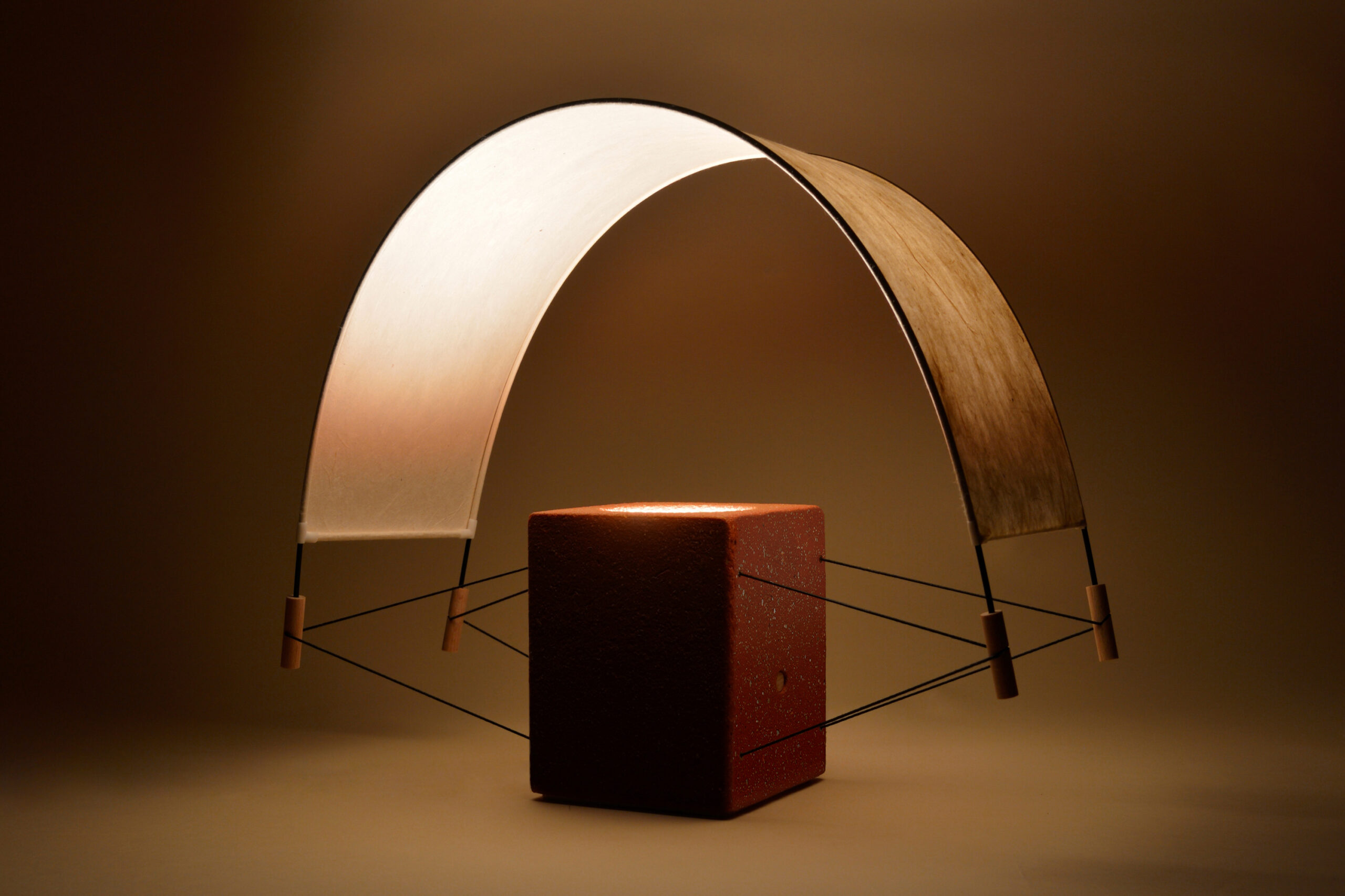 Écla Terracotta, petite lampe à poser allumée, en papier washi et terre cuite.