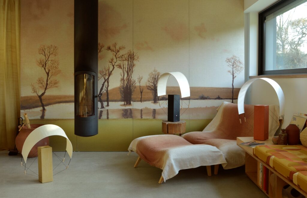 Photographie des lampes Lumia dans un intérieur design et artistique. Il y a les trois finitions, terre cuite, terre crue et terre peinte en noir positionnées sur différentes surfaces.