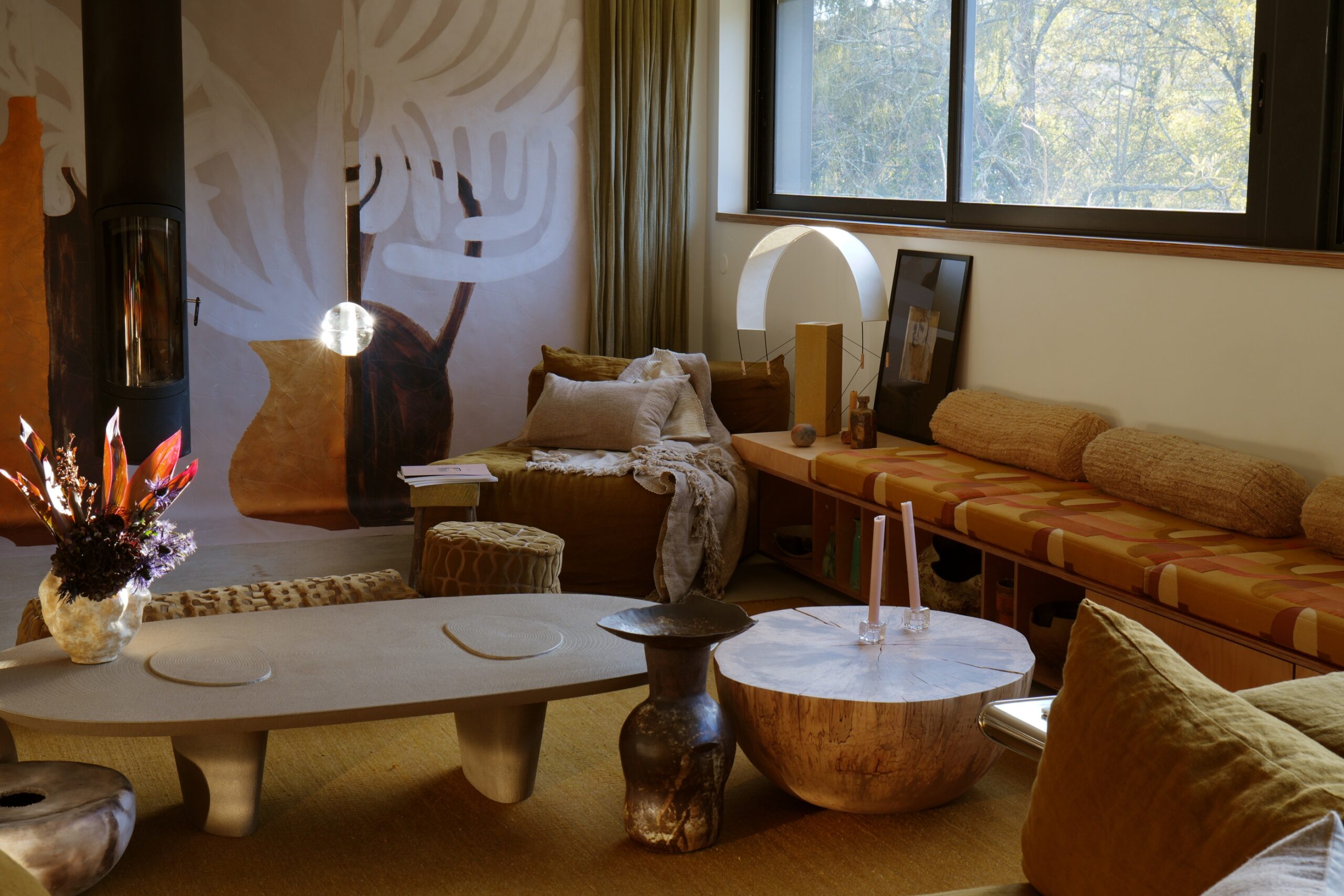 Photographie de la lampe à poser lumia en terre cuite avec un jeu d'ombres portées. Elle est entourée d'objets artisanaux design et contemporain et se marie à perfection dans se décor