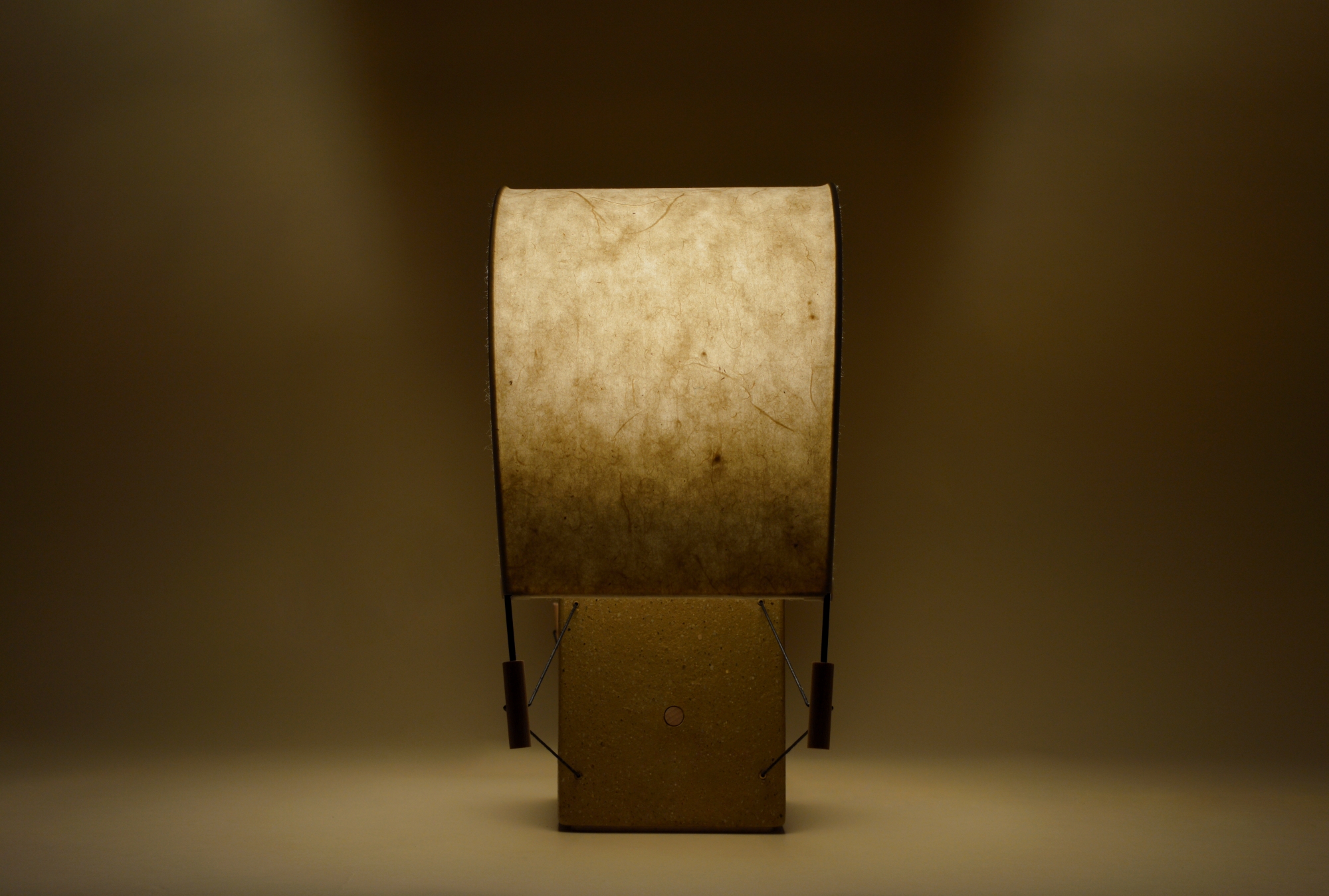 Écla Terre Crue, petite lampe à poser allumée, en papier washi et terre crue, vue de profil.