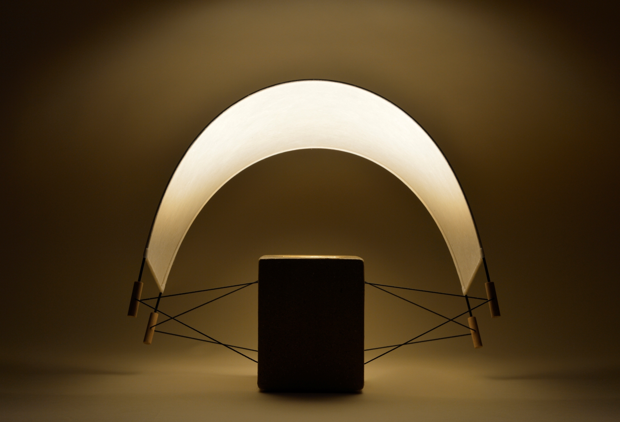 Écla Terre Crue, lampe à poser allumée en papier washi er terre crue avec l'abat-jour incliné vers l'arrière.