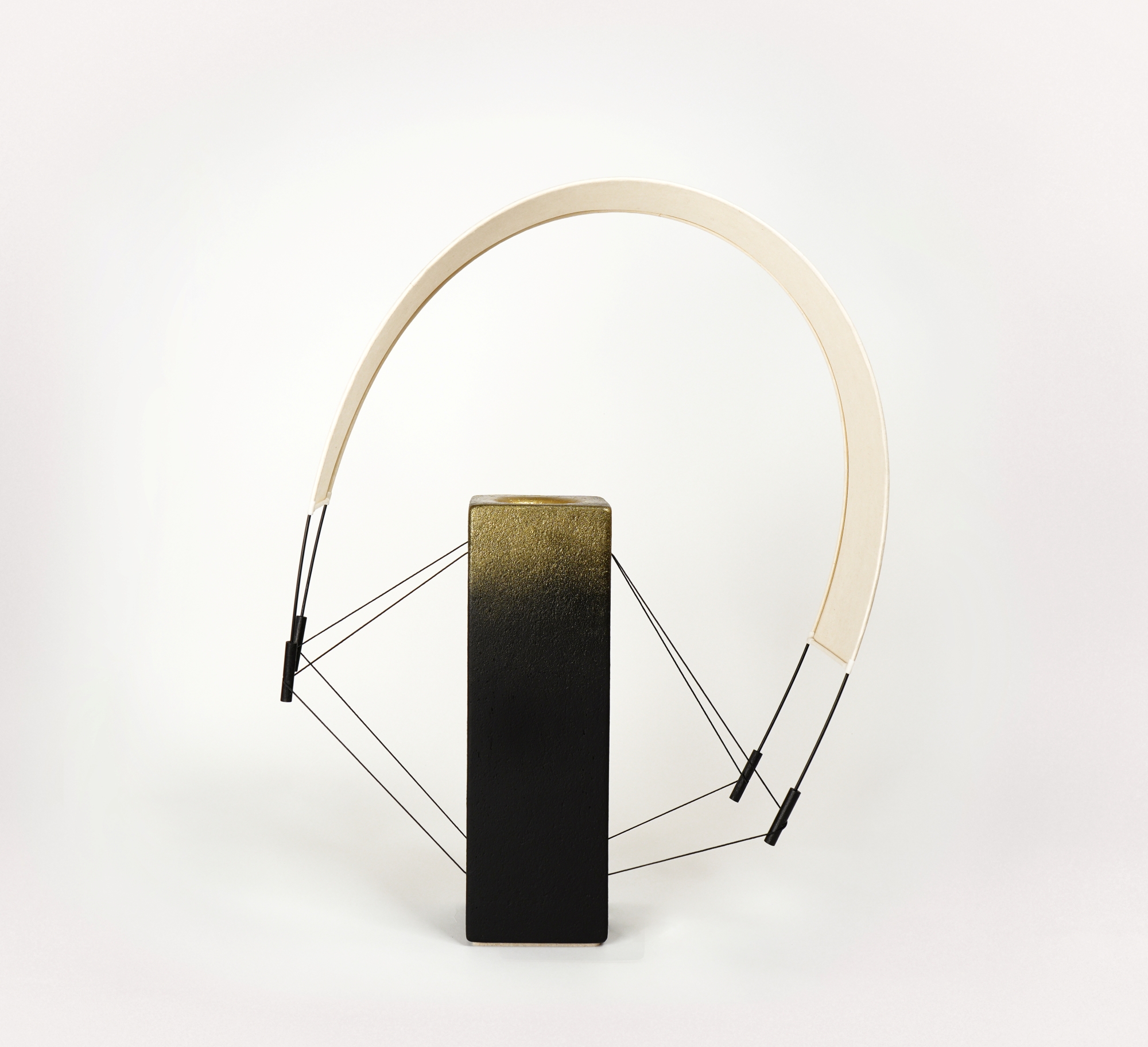 Lumia d'Or est une pièce unique de la collection Aura imaginée par Maison Cédrat. Réalisée en terre cuite noire et sublimée par une finition à la poudre de laiton, cette création diffuse une lumière douce et célèbre le savoir-faire artisanal. Image produit.
