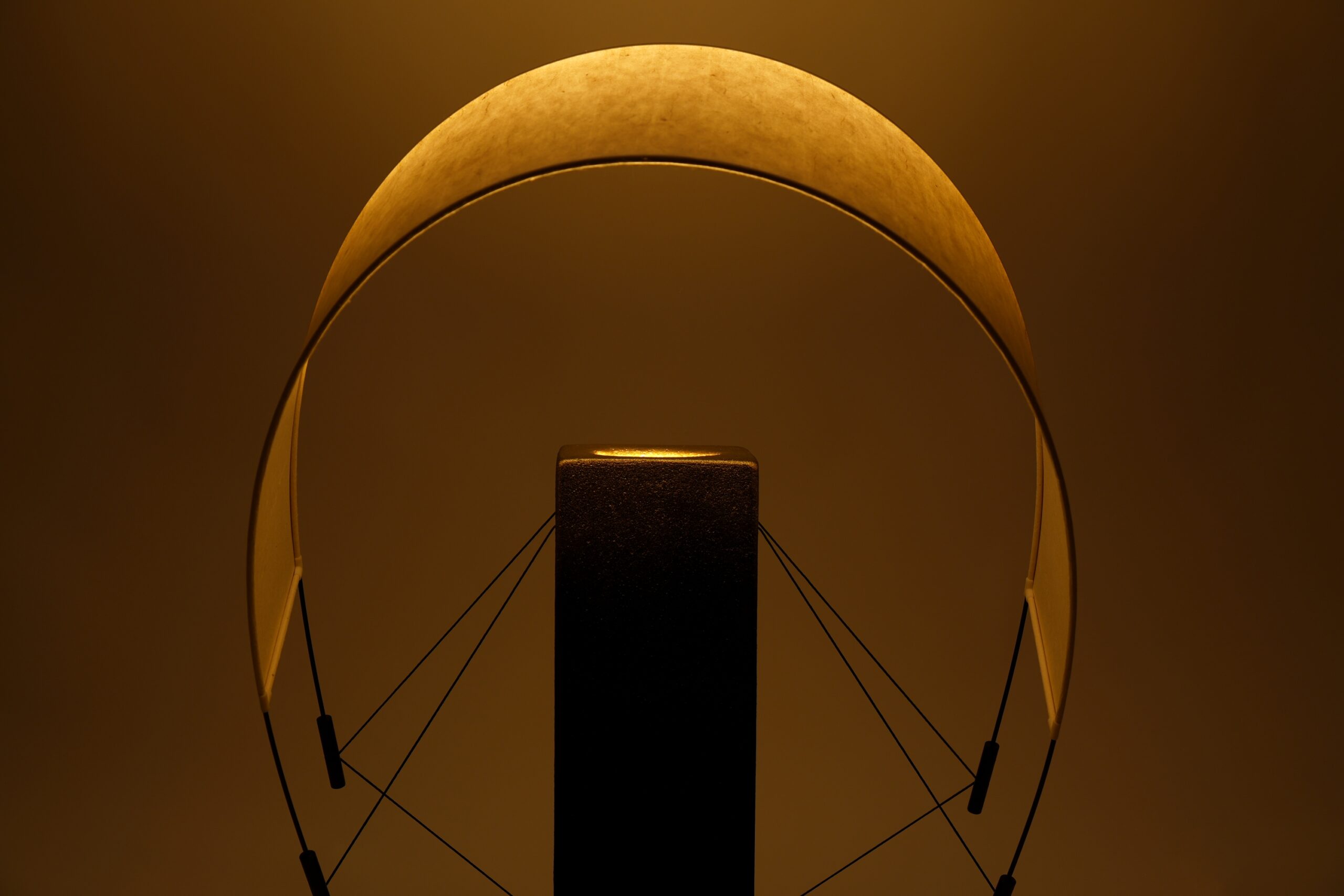 Gros plan sur Lumia d'Or allumée. La lumière traverse délicatement le papier washi et met en valeur les finitions artisanales de cette lampe à poser en terre cuite, créée en pièce unique en collaboration avec le chocolatier Thierry Papereux.