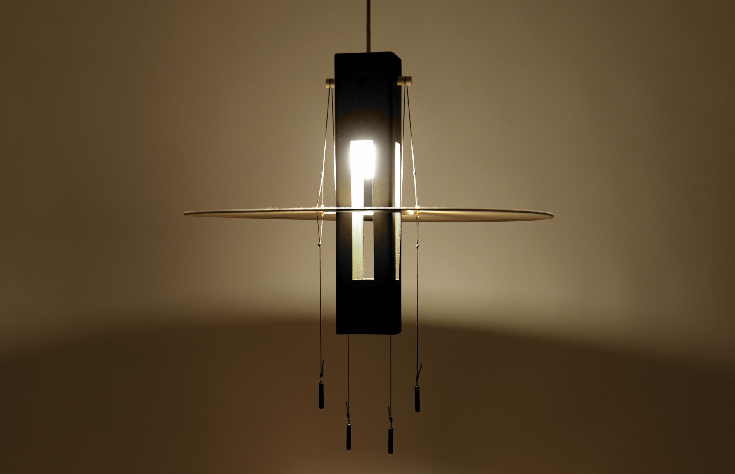 Nova Noire vue de face, Suspension lumineuse allumée en terre cuite peinte en noir et papier washi suspendue.
