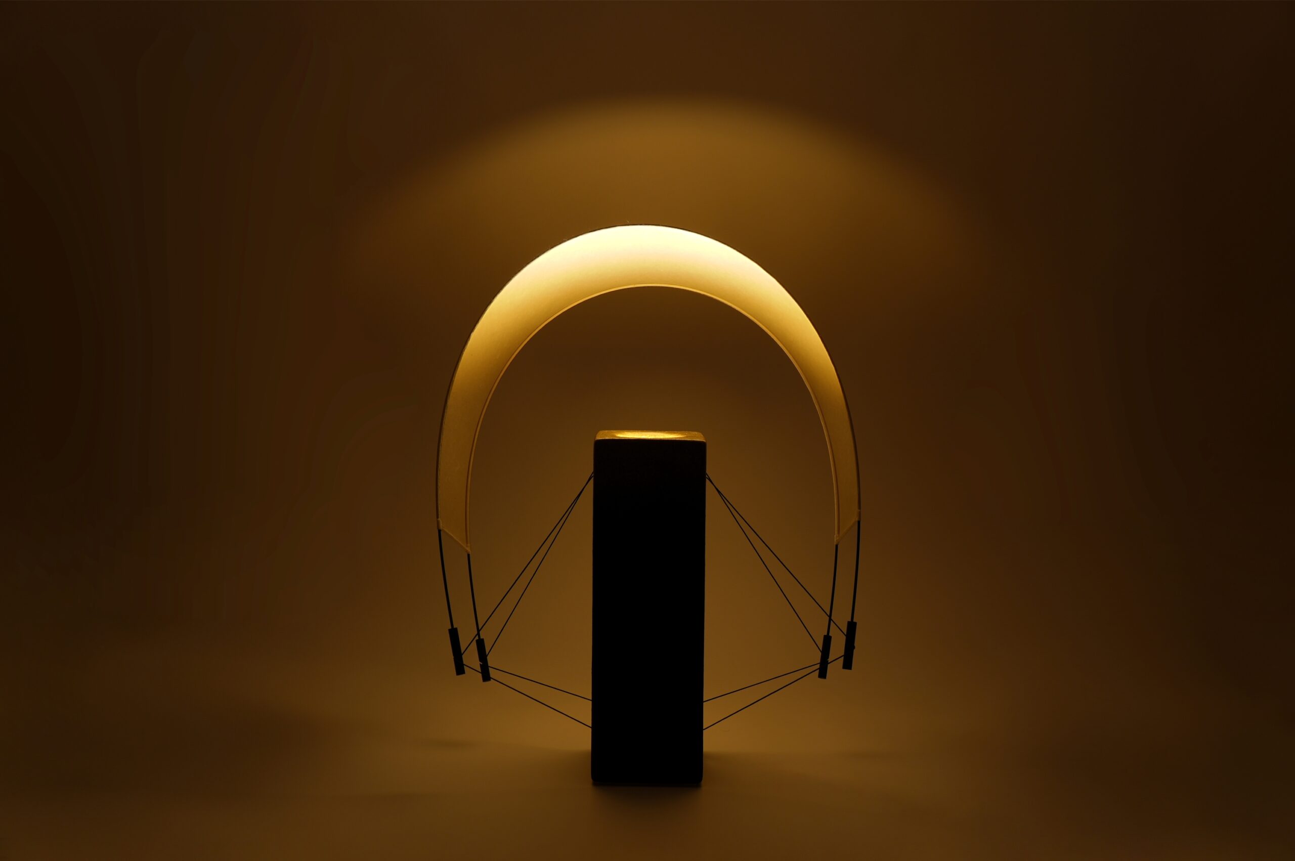 Lumia d'Or allumée avec sa voile en papier washi orientée vers l'arrière. Cette configuration révèle une nouvelle perception de la lumière et souligne la silhouette contemporaine de cette pièce unique créée en collaboration avec le chocolatier Thierry Papereux.