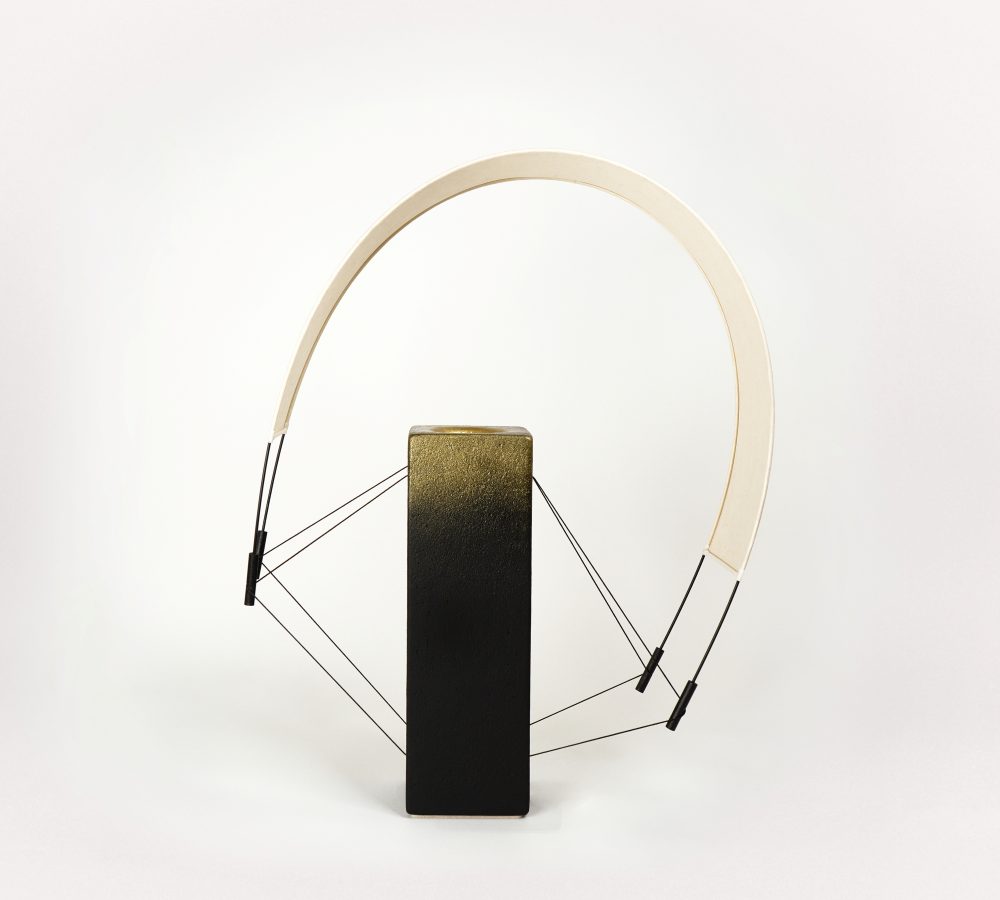 Lumia d'Or est une pièce unique de la collection Aura imaginée par Maison Cédrat. Réalisée en terre cuite noire et sublimée par une finition à la poudre de laiton, cette création diffuse une lumière douce et célèbre le savoir-faire artisanal. Image produit.
