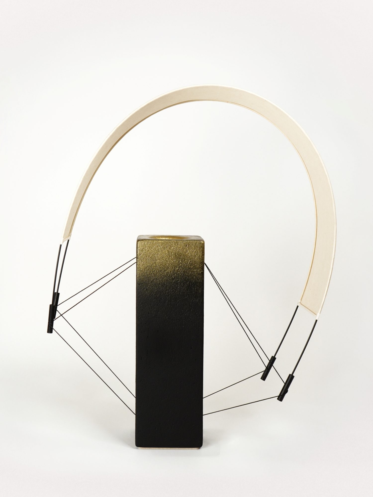 Lumia d'Or est une pièce unique de la collection Aura imaginée par Maison Cédrat. Réalisée en terre cuite noire et sublimée par une finition à la poudre de laiton, cette création diffuse une lumière douce et célèbre le savoir-faire artisanal. Image produit.
