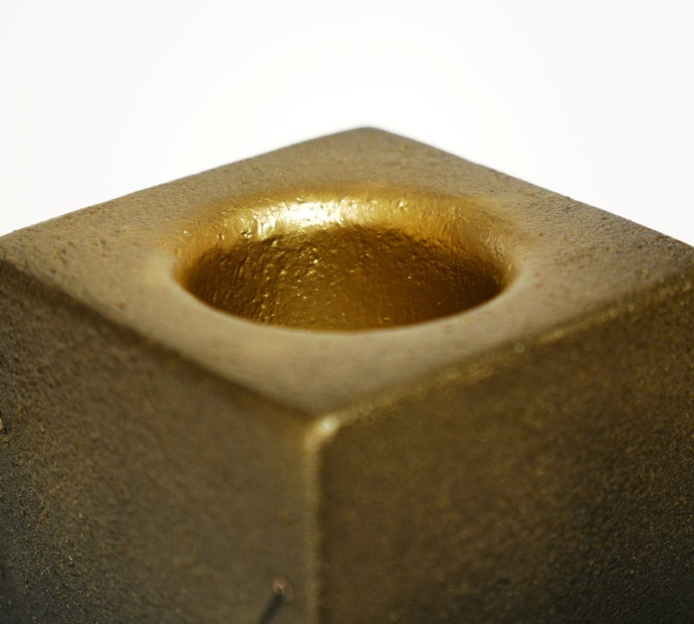 Gros plan sur la finition dorée de la lampe à poser Lumia d'Or. Réalisée en pièce unique dans le cadre d'une collaboration avec le chocolatier Thierry Papereux, cette finition fait écho aux emblématiques Palets d'Or et révèle le caractère artisanal de la création.