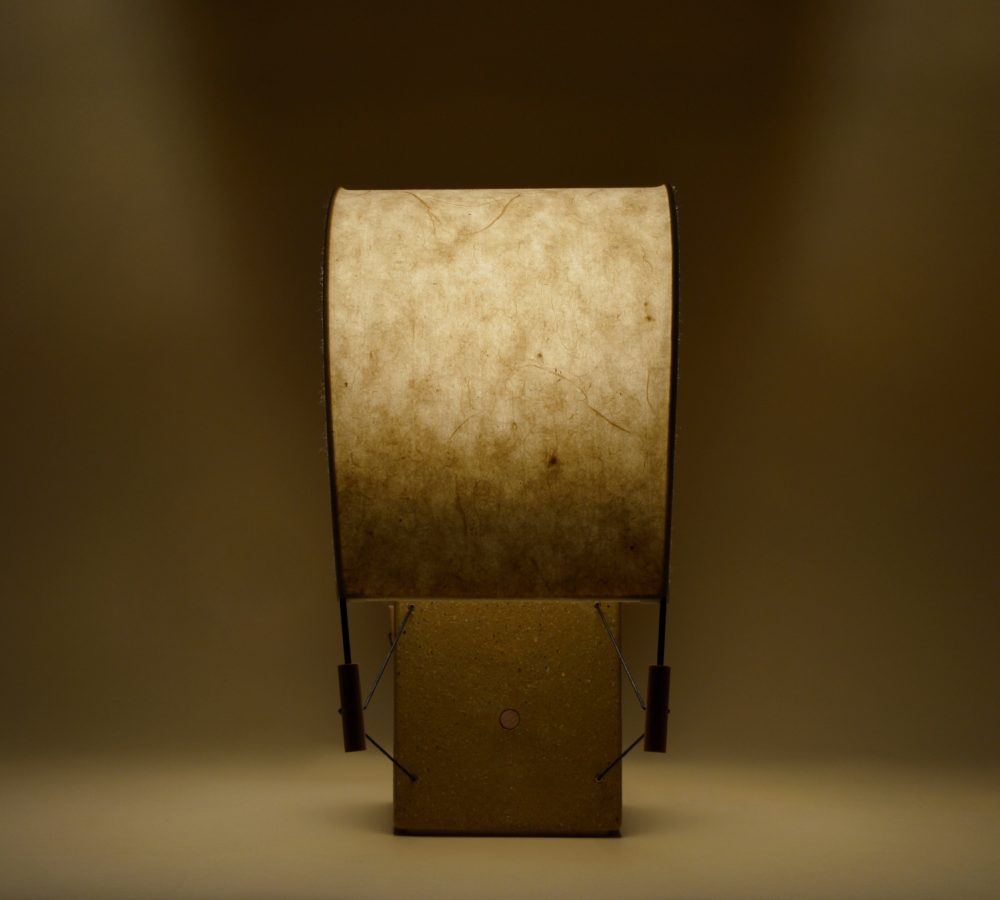 Écla Terre Crue, petite lampe à poser allumée, en papier washi et terre crue, vue de profil.
