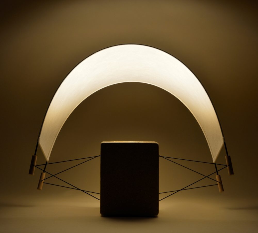 Écla Terre Crue, lampe à poser allumée en papier washi er terre crue avec l'abat-jour incliné vers l'arrière.