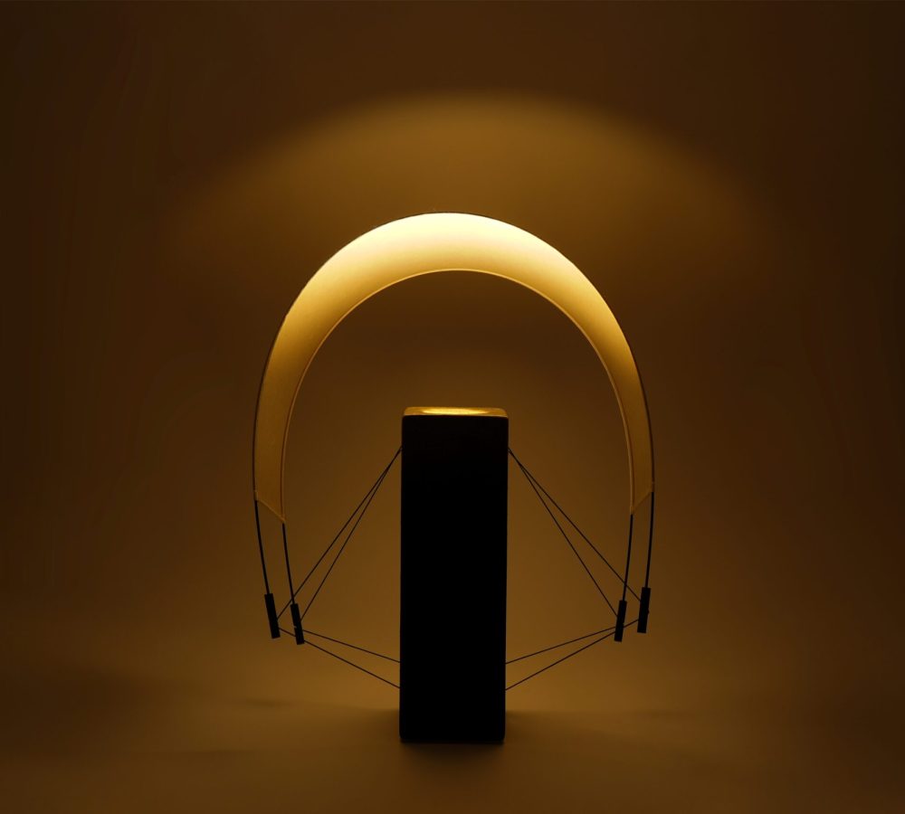 Lumia d'Or allumée avec sa voile en papier washi orientée vers l'arrière. Cette configuration révèle une nouvelle perception de la lumière et souligne la silhouette contemporaine de cette pièce unique créée en collaboration avec le chocolatier Thierry Papereux.