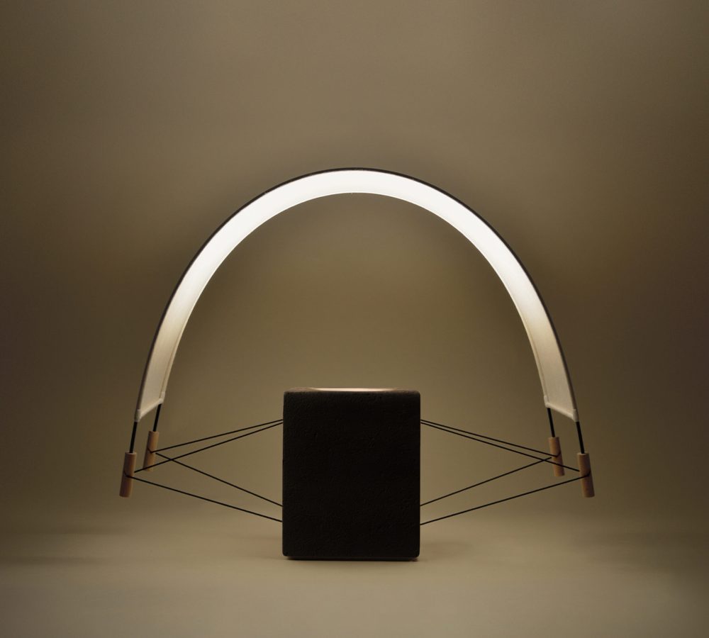 Vue de face de la lampe à poser Écla Noire allumée, en terre cuite peinte en noir et papier washi, de la collection Aura par Maison Cédrat.